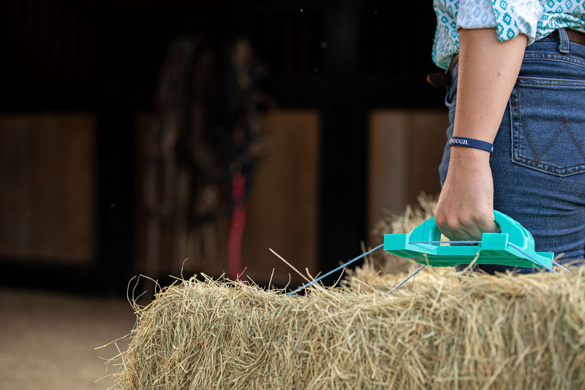 reinsman bale handle in turquoise lifting hay